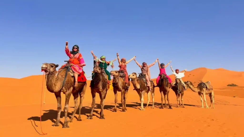 private 3 days desert tour from Marrakech Camel trekking in Merzouga — dromedary caravan crossing the Erg Chebbi dunes at sunset, Sahara Desert, Morocco