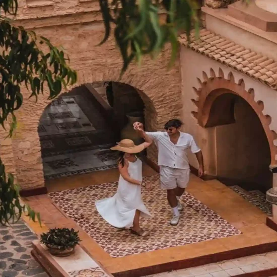 Couple enjoying a romantic moment dancing in a traditional Moroccan riad courtyard during a 4 days tour from Agadir to Marrakech