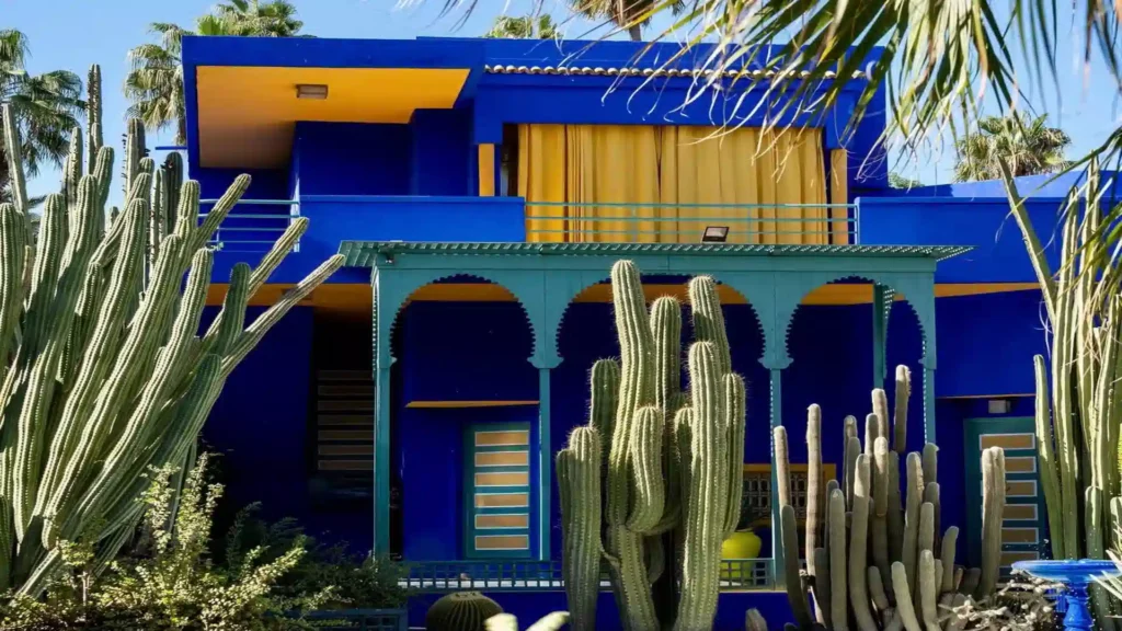 Majorelle Garden Marrakech — the iconic Majorelle Blue villa reflected in the lily pond at opening time, Jardin Majorelle 2026