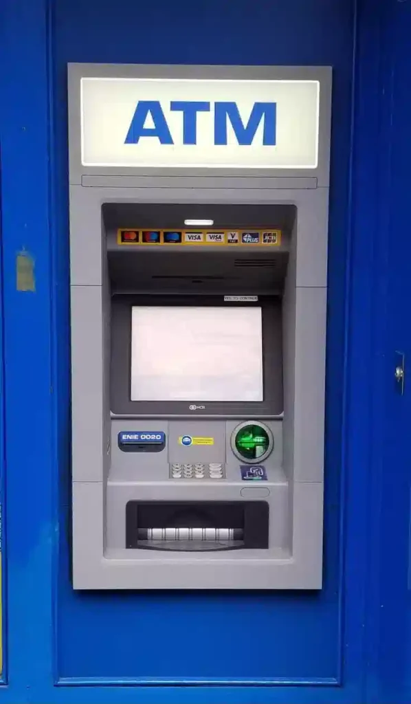 A standard bank ATM machine set into a blue wall answering do I need cash in Morocco for travelers withdrawing dirhams