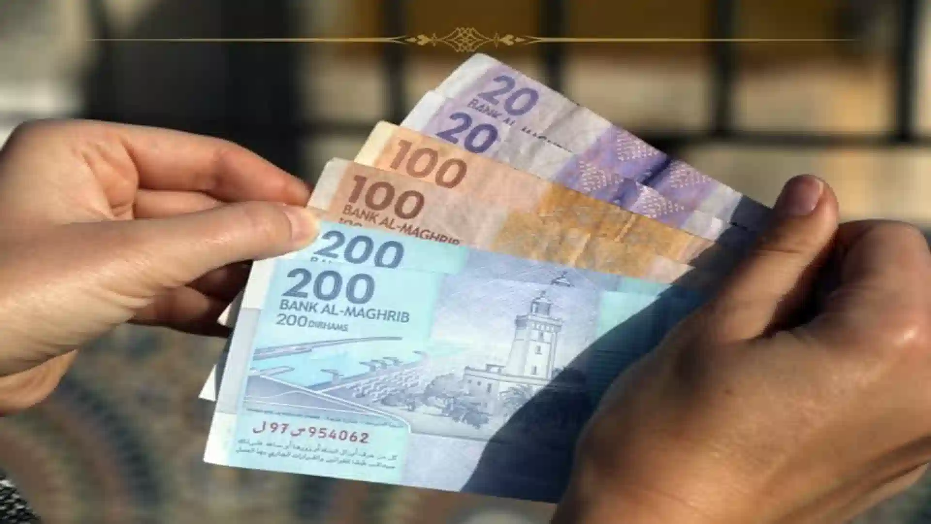 Close-up of hands counting Bank Al-Maghrib 20, 100, and 200 dirham banknotes to show do I need cash in Morocco.