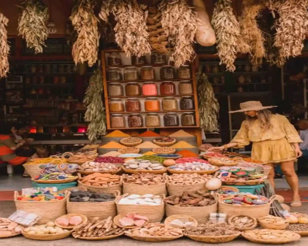 Traveler browsing woven baskets of spices, dried herbs, and pigments in an outdoor stall from the 7 best souks in Marrakech.