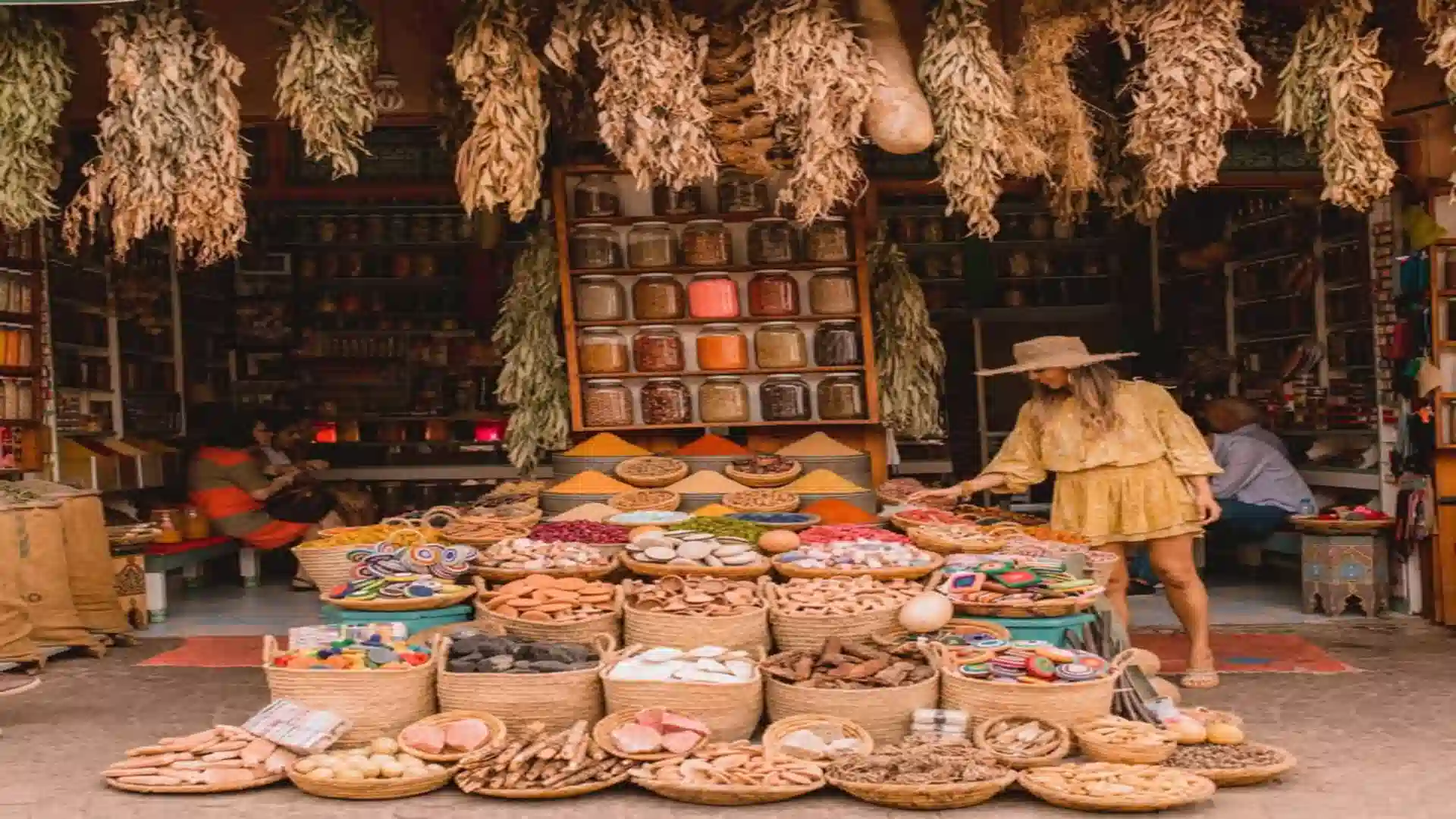 Traveler browsing woven baskets of spices, dried herbs, and pigments in an outdoor stall from the 7 best souks in Marrakech.